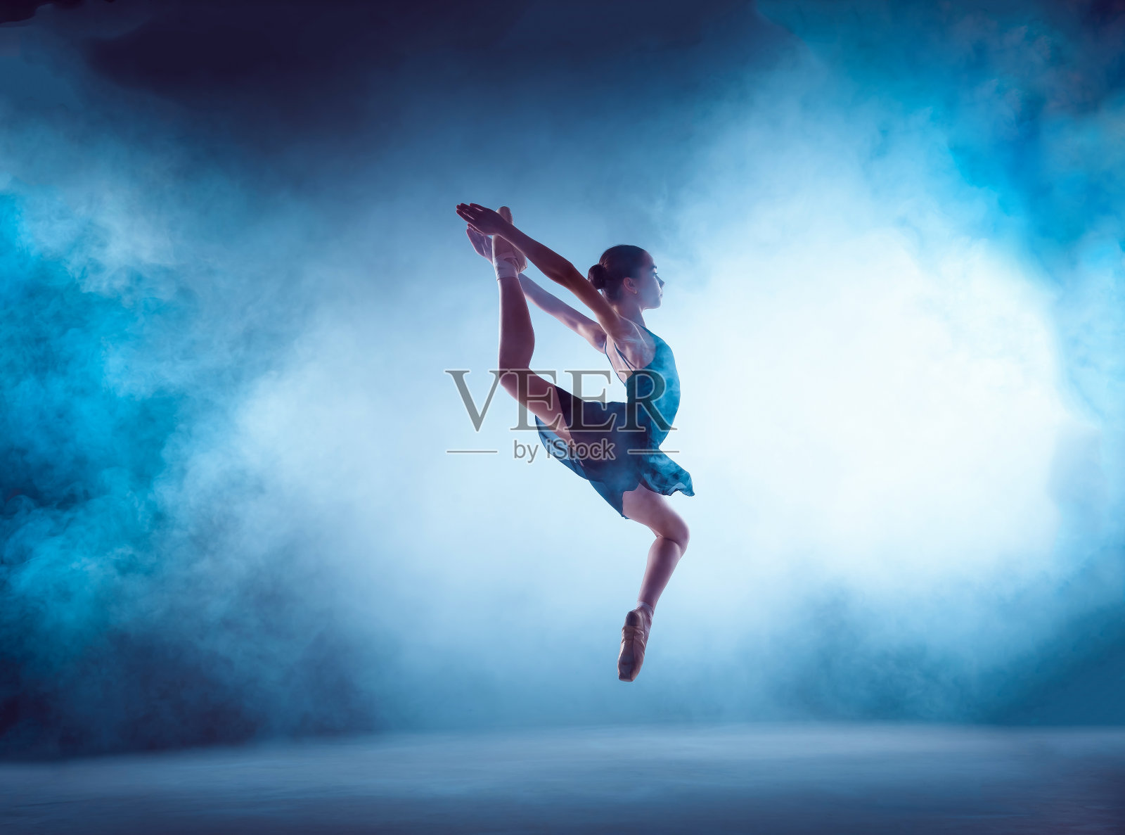 美丽的年轻芭蕾舞者在丁香背景上跳跃照片摄影图片