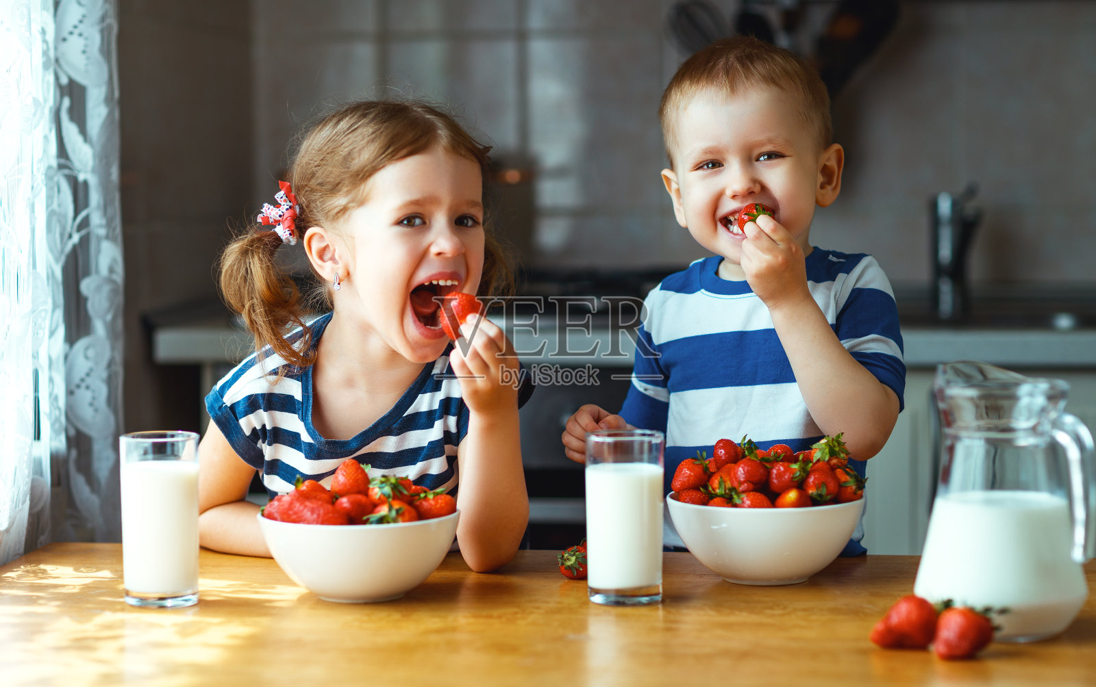 快乐的小朋友们，弟弟妹妹吃草莓加牛奶照片摄影图片