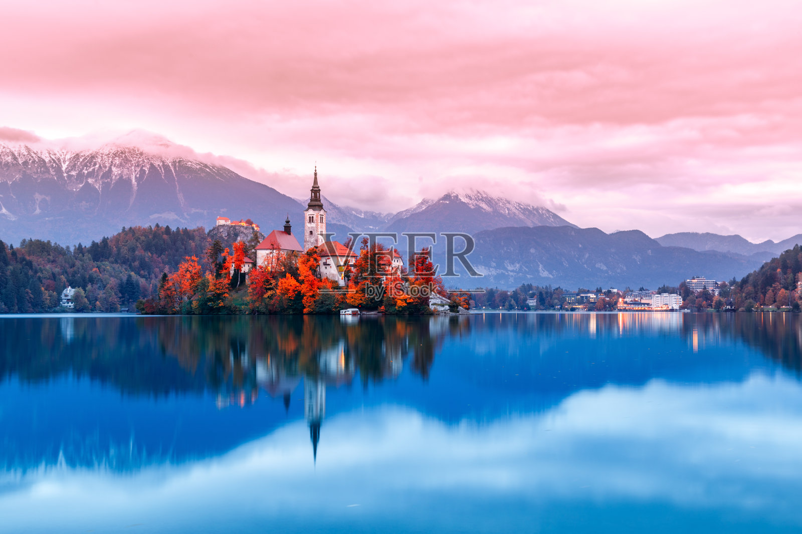斯洛文尼亚的流血湖，著名和非常受欢迎的地标和旅游目的地。在布莱德湖中央有一座古老教堂的岛屿夜景。浪漫的地方，日落黄昏的风景。秋天的季节。照片摄影图片