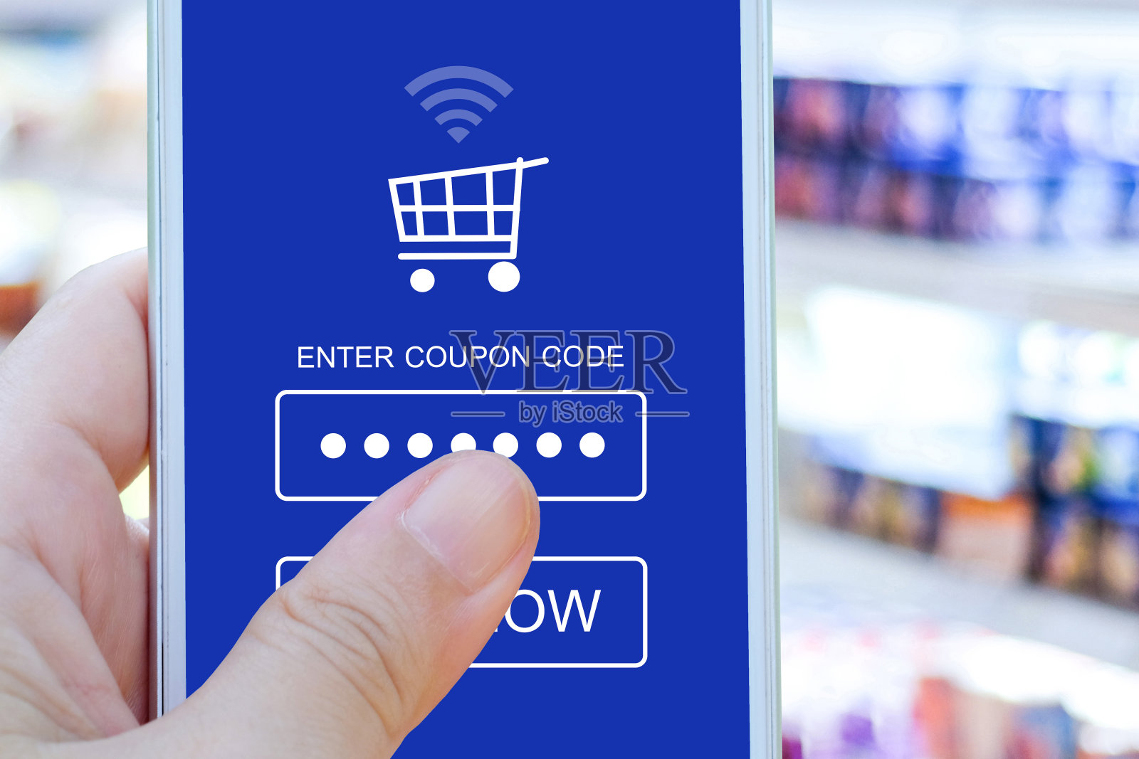 手持智能手机与折扣券代码在屏幕上模糊超市背景，网上购物，商务，电子商务，技术和数字营销背景照片摄影图片