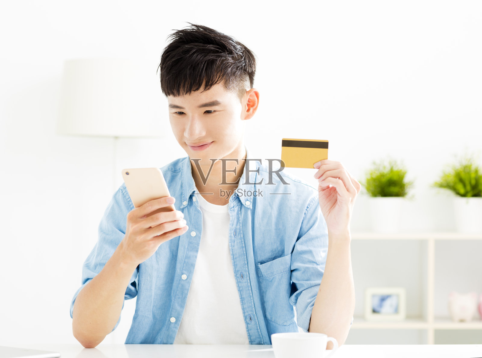 年轻人用信用卡和智能手机在网上购物照片摄影图片