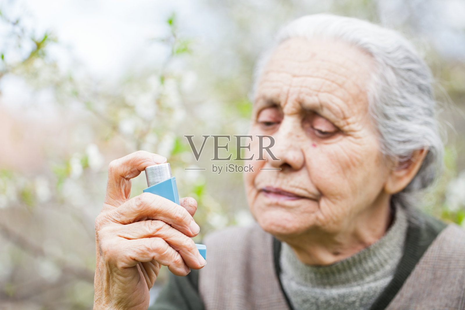 老年妇女哮喘发作，拿着支气管扩张剂照片摄影图片