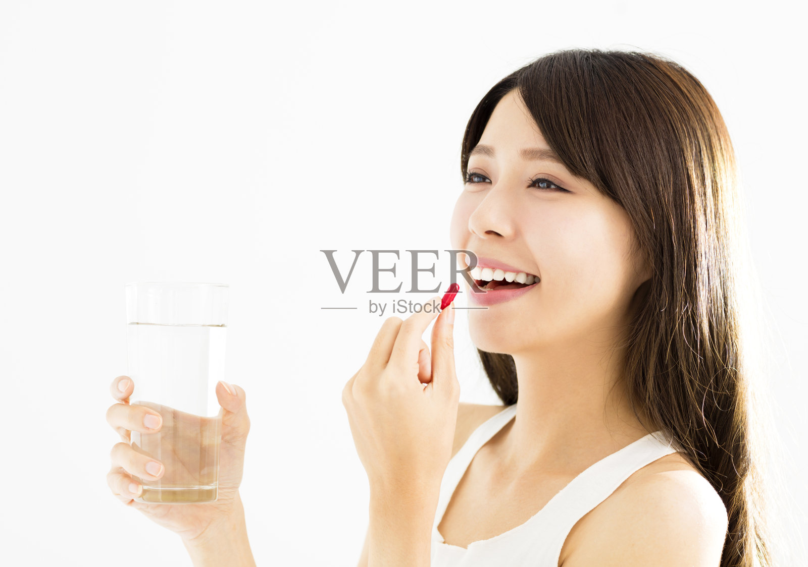 微笑的年轻女子吃着药丸照片摄影图片