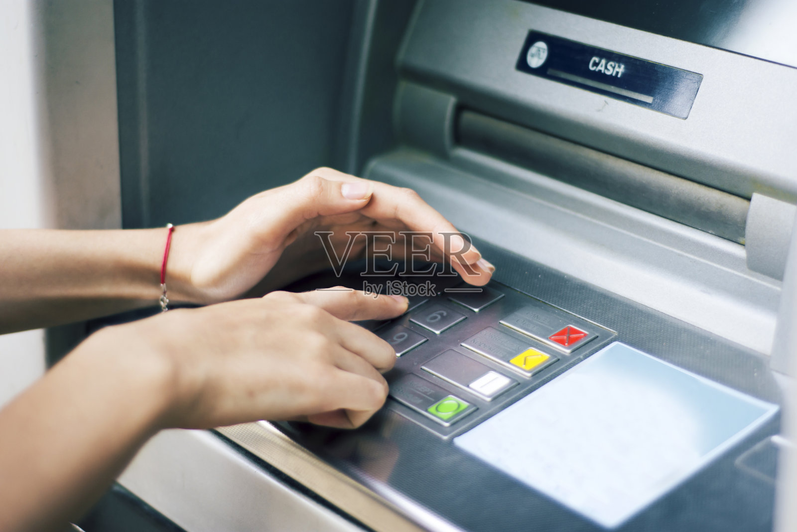 一个女人从自动取款机上取钱照片摄影图片