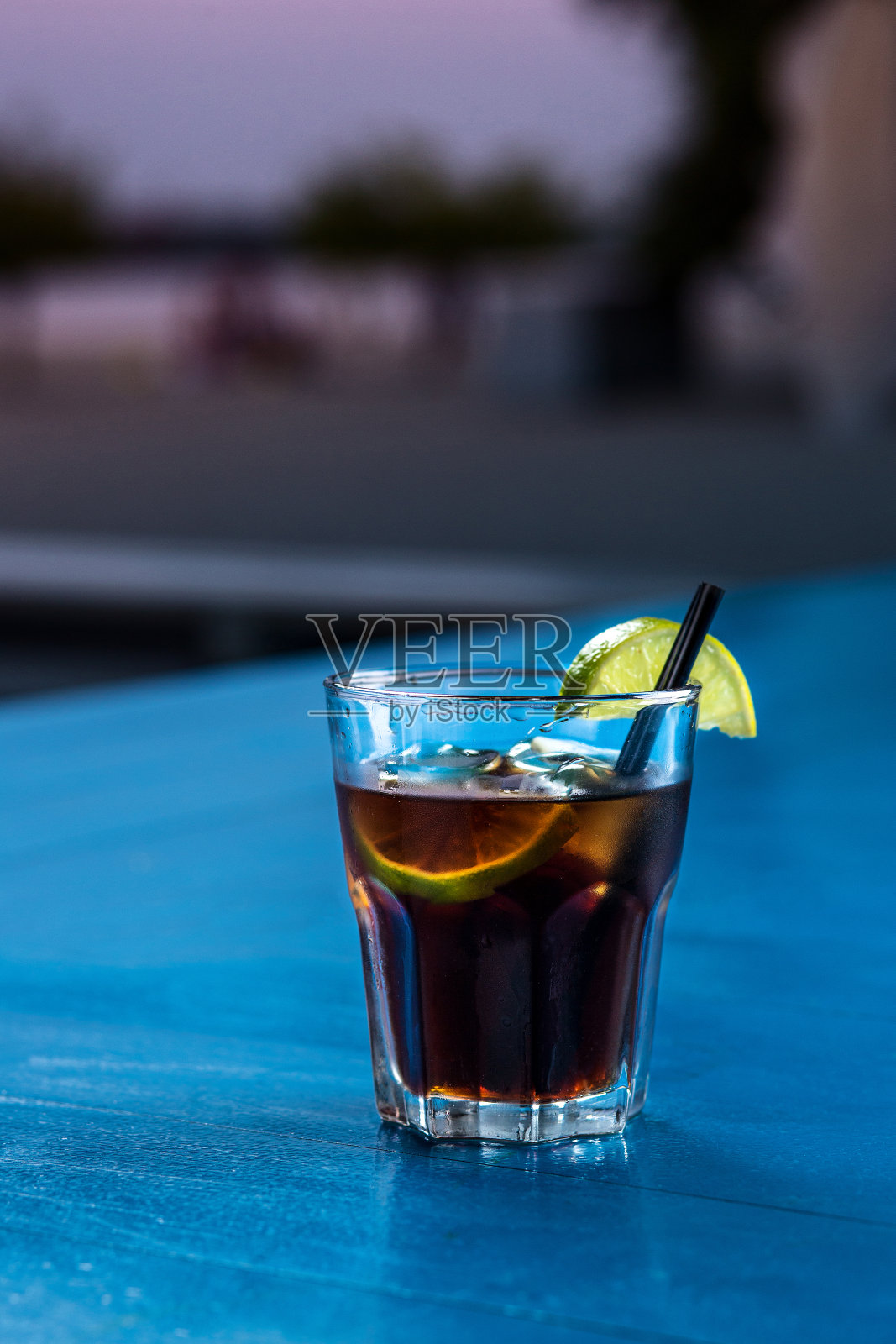 朗姆酒可乐随意鸡尾酒与冰块和酸橙在夏季酒吧的背景照片摄影图片