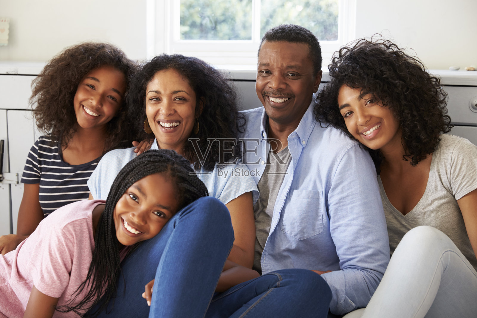 微笑的家庭在家里的座位上放松的肖像照片摄影图片