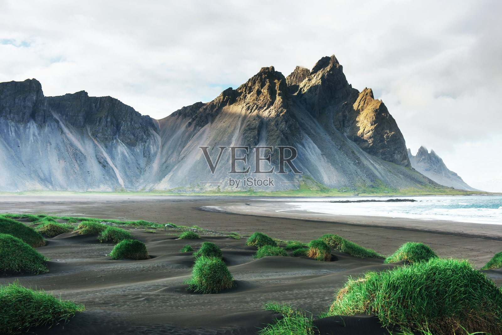 冰岛斯托克尼斯海滩上的山脉和火山熔岩沙丘的奇妙西部。照片摄影图片