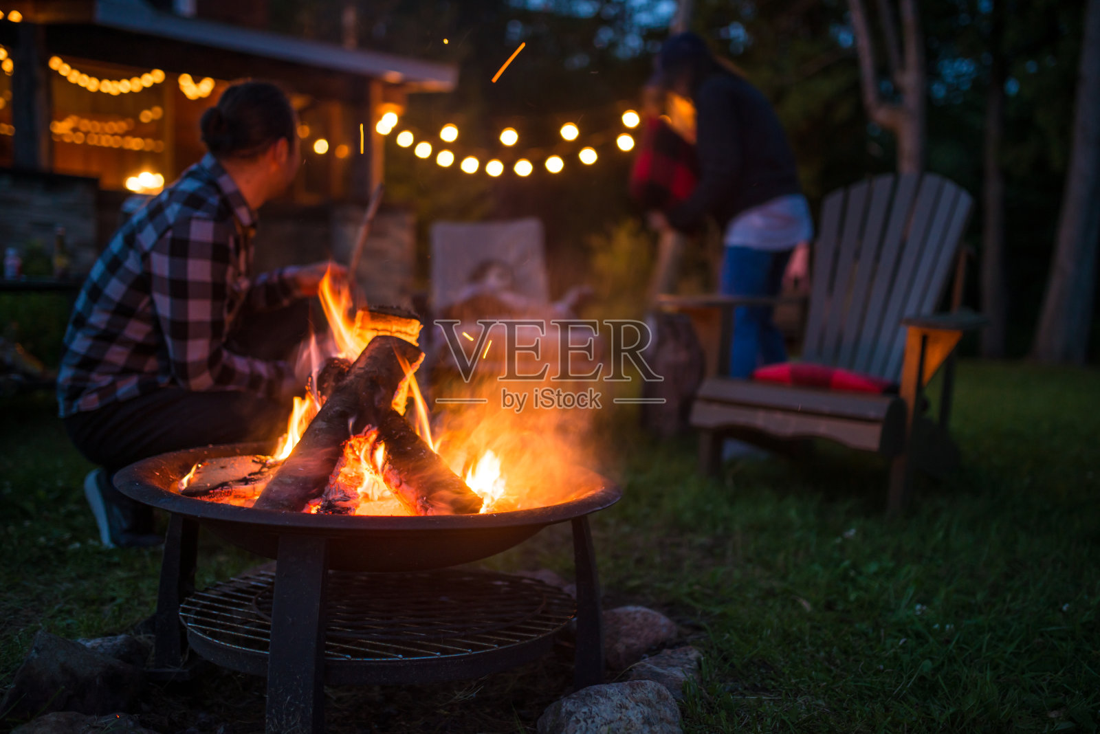 在一个美丽的加拿大小木屋里，父亲和女儿在篝火旁取暖照片摄影图片