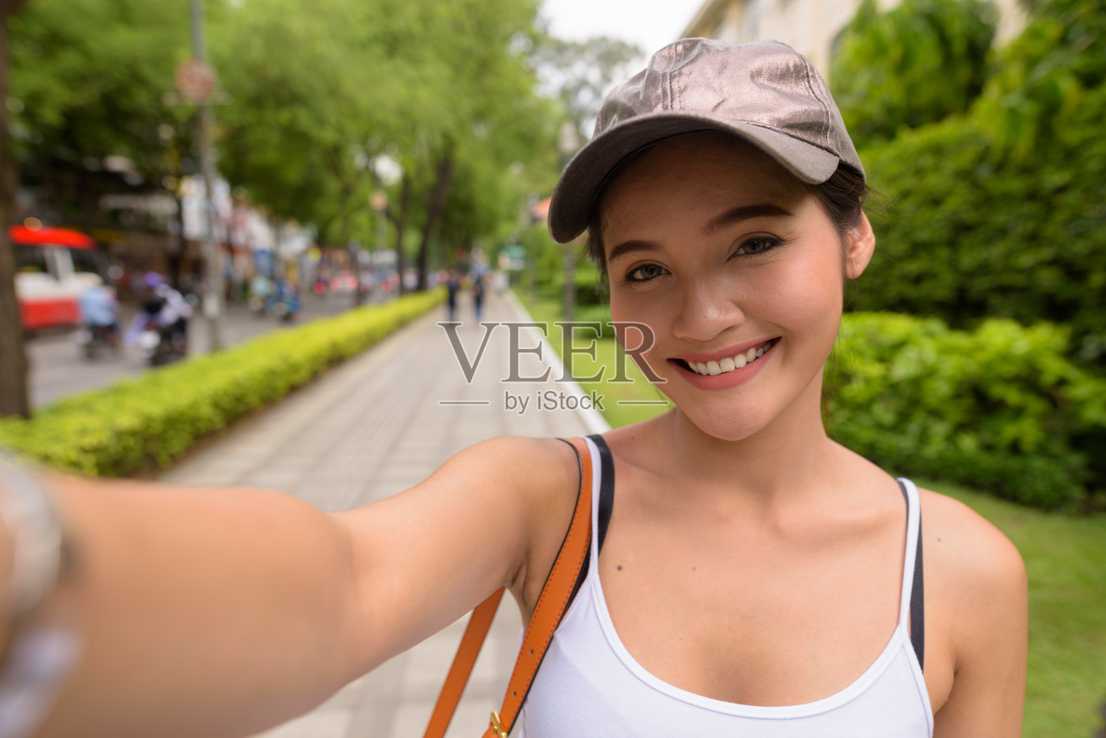 年轻美丽的亚洲女游客在越南胡志明市的街道上拍视频照片摄影图片