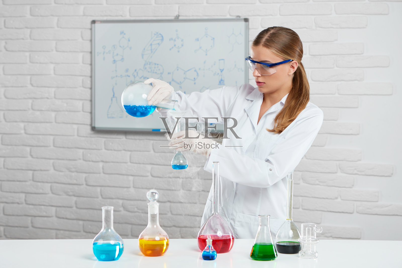 一名年轻女子在混合彩色化学液体照片摄影图片