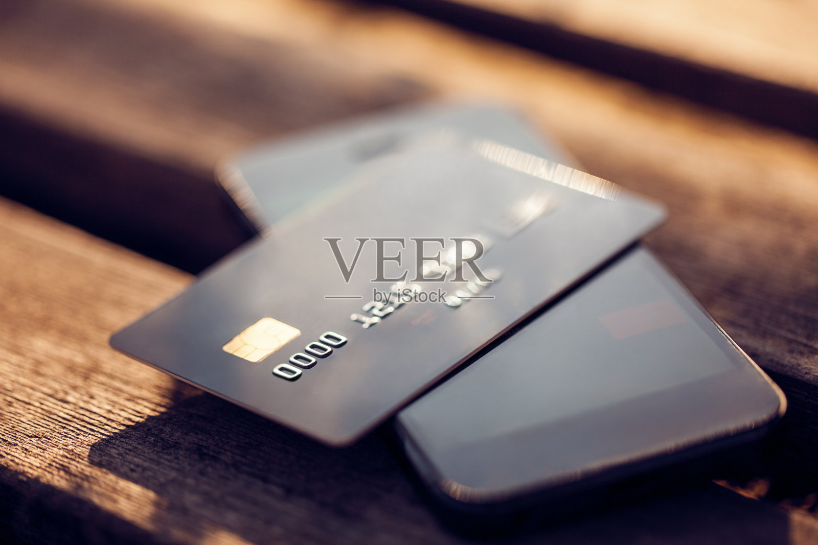 木质背景上的信用卡和手机。照片摄影图片
