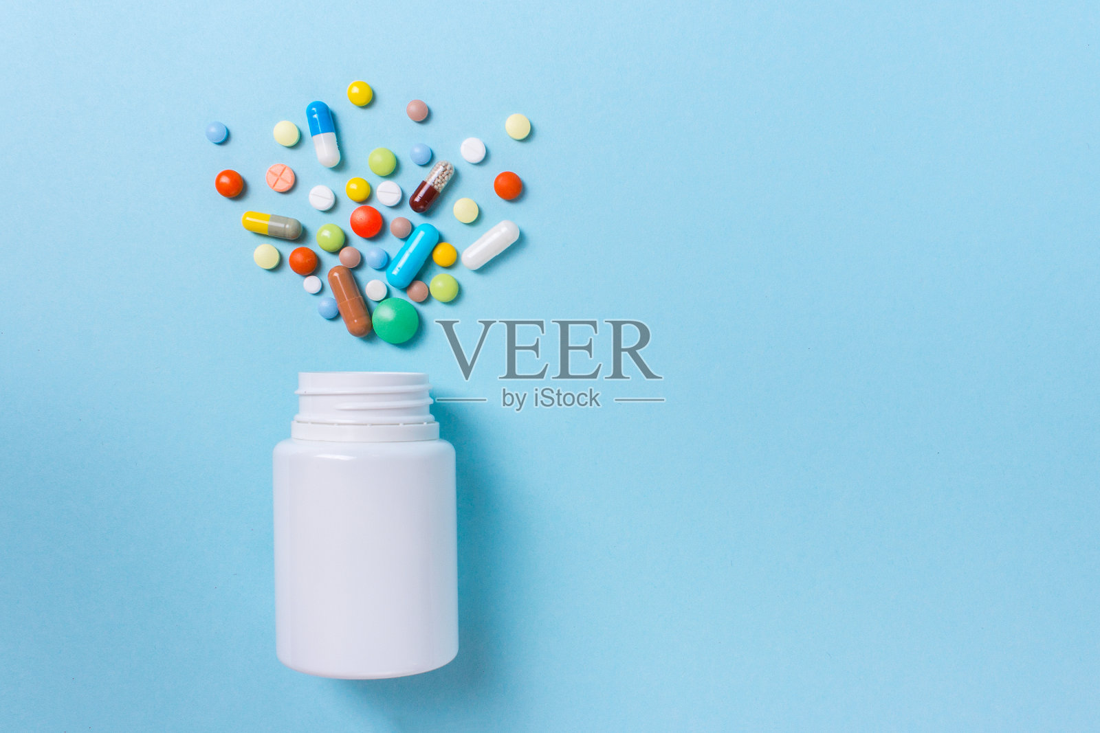 各种药物，药片，胶囊和瓶子在蓝色的背景。文本复制空间照片摄影图片