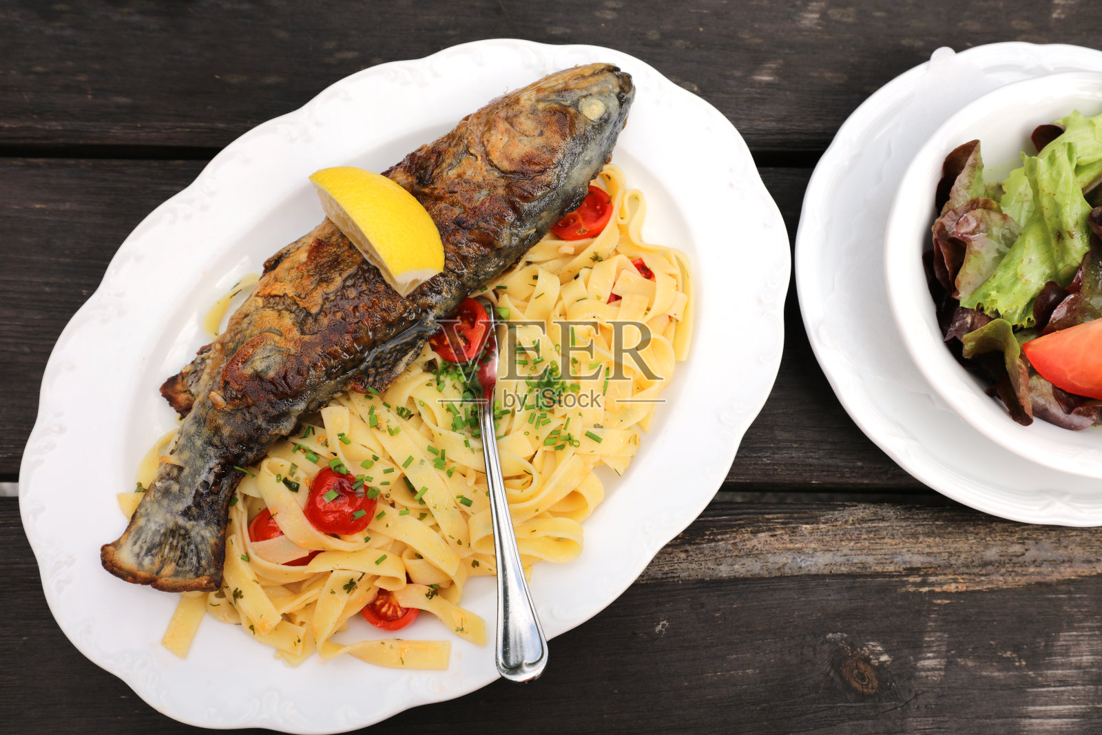 奥地利蒂罗尔的新鲜烤鳟鱼配意大利细面条照片摄影图片