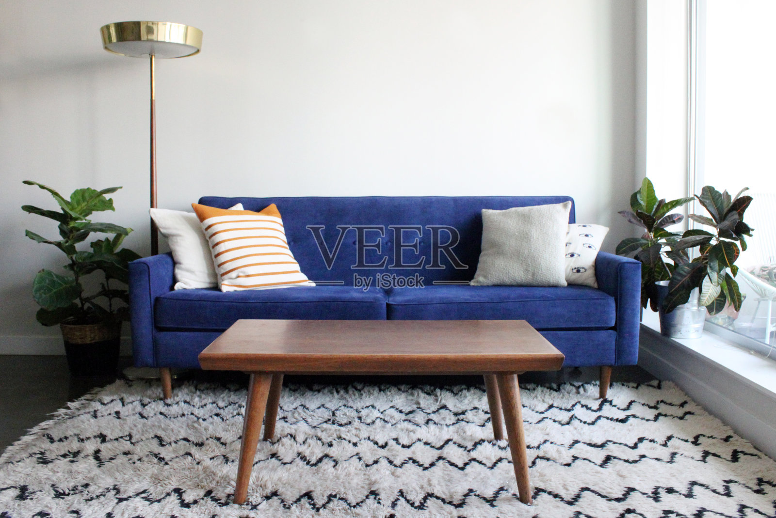 蓝色麂皮中世纪现代沙发在极简主义公寓设置照片摄影图片