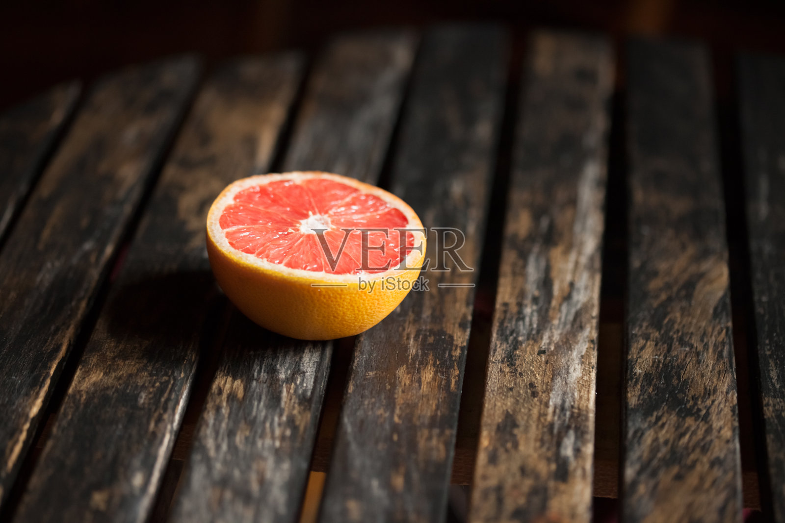 熟红橙黄放在木桌上，横截面照片摄影图片