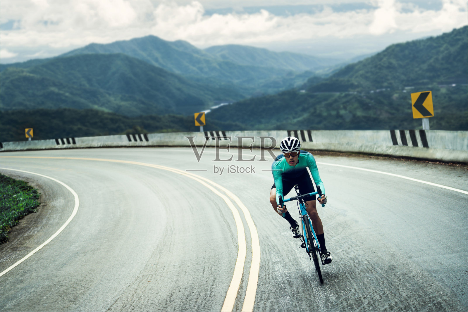 骑自行车的人骑着自行车，向山顶爬去。照片摄影图片