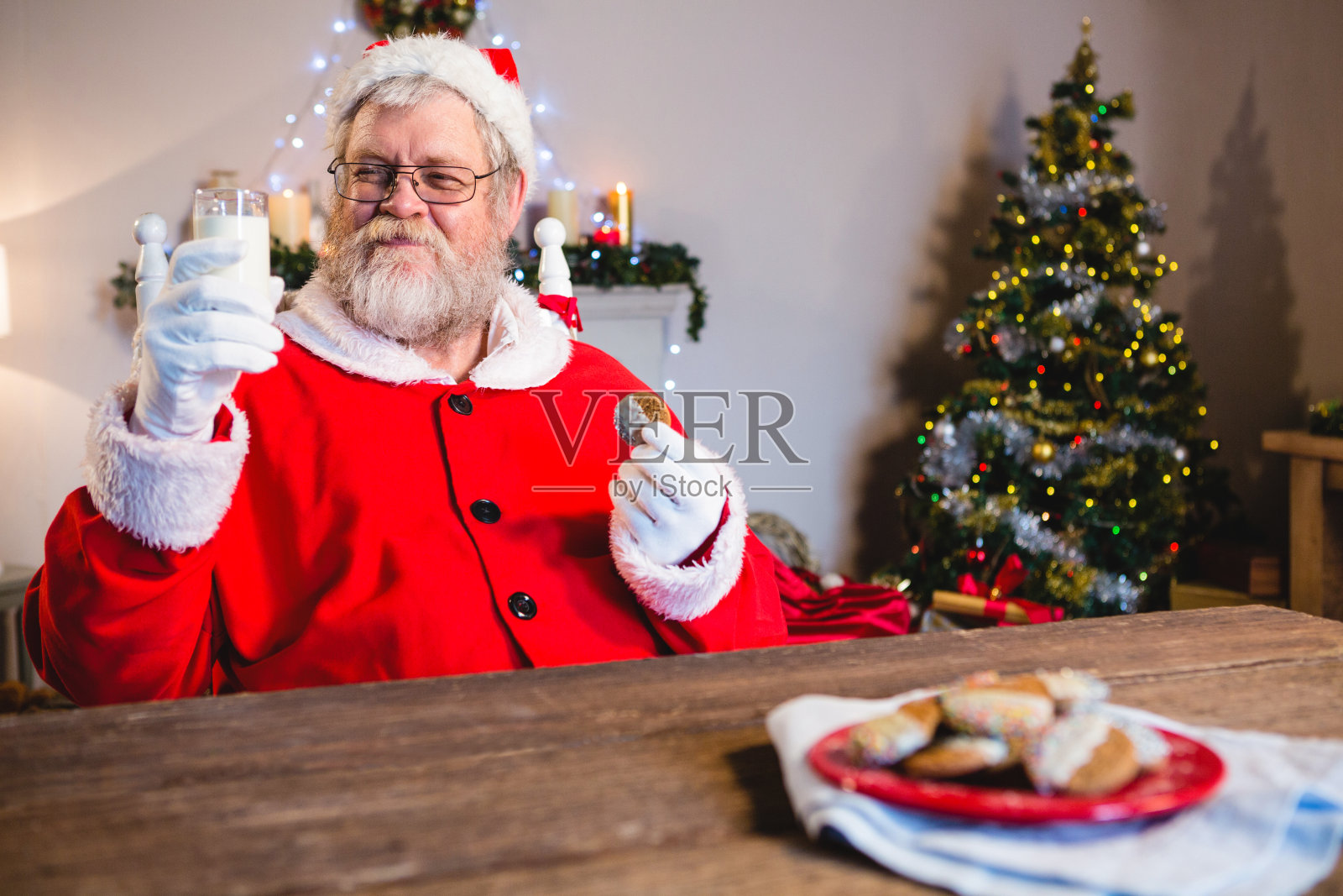 圣诞老人吃着饼干和一杯牛奶照片摄影图片
