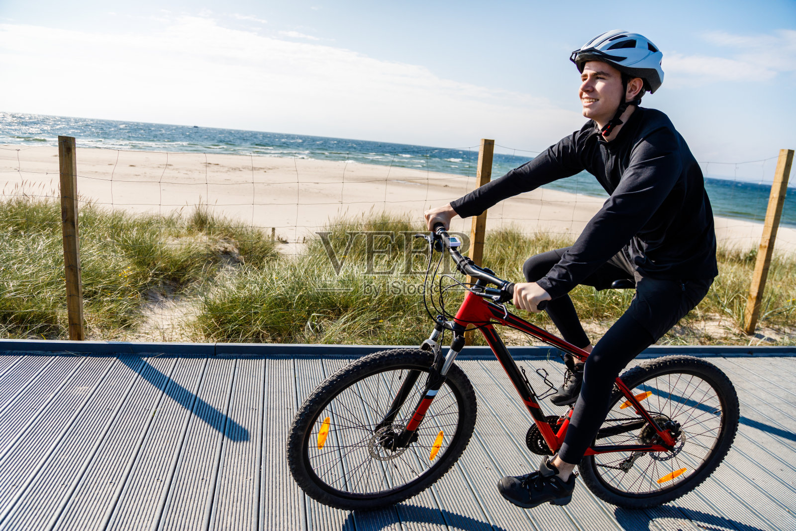 在海边骑自行车的年轻人照片摄影图片