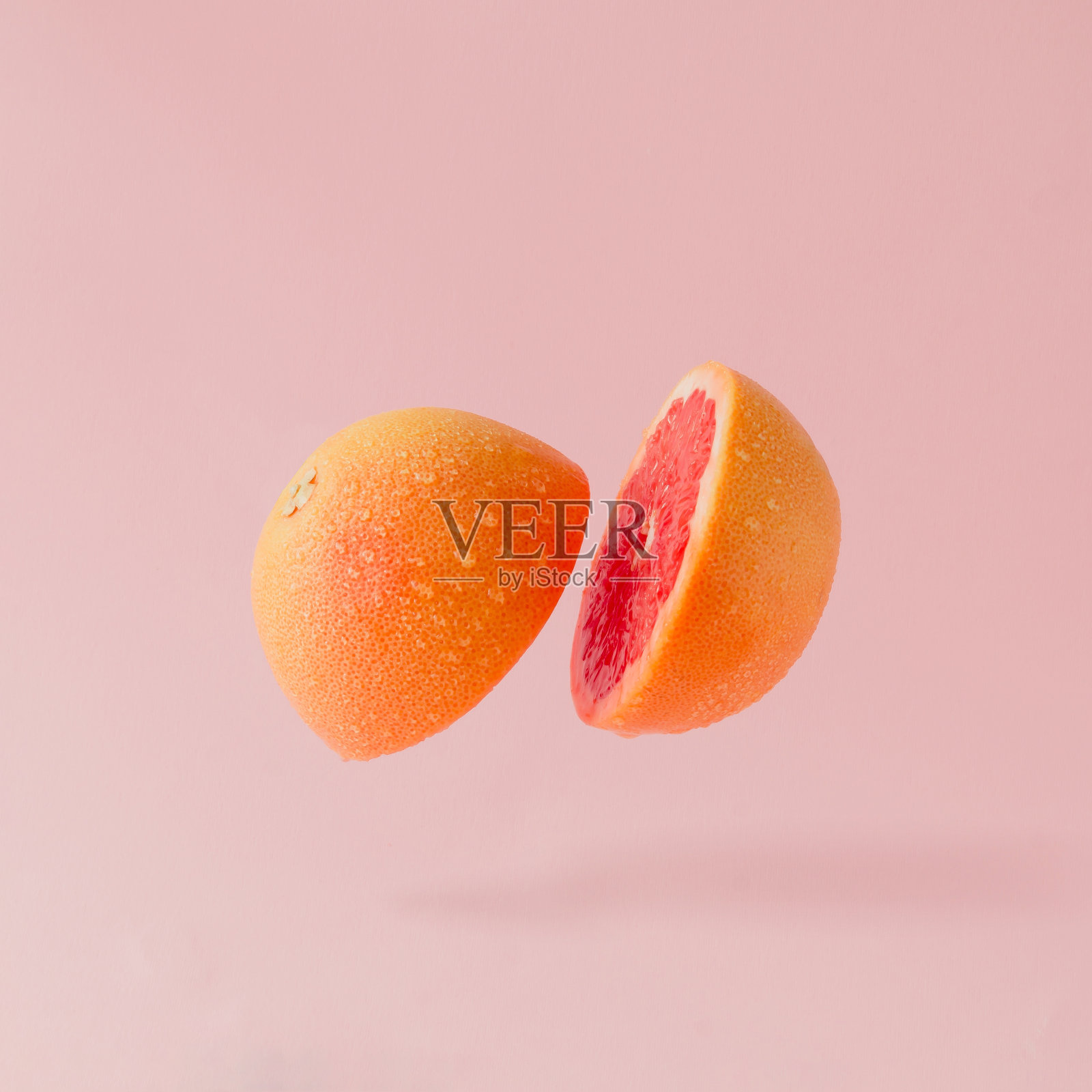 柚子切片，背景为淡粉色。最小的水果的概念。照片摄影图片
