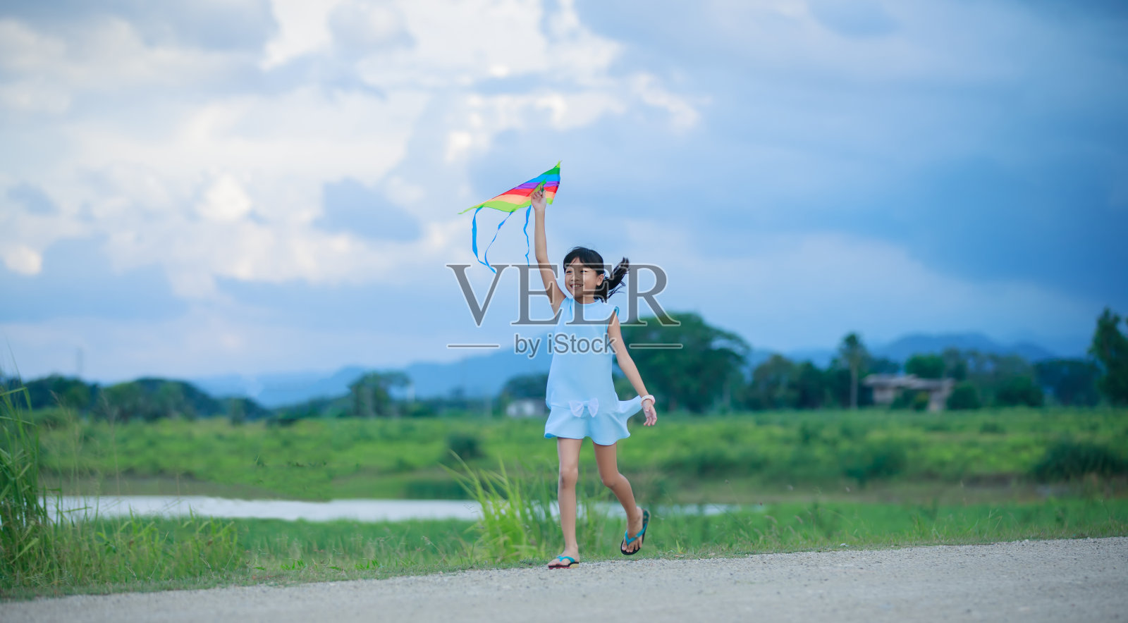 亚洲儿童女孩与风筝跑和快乐的草地在夏季的自然照片摄影图片