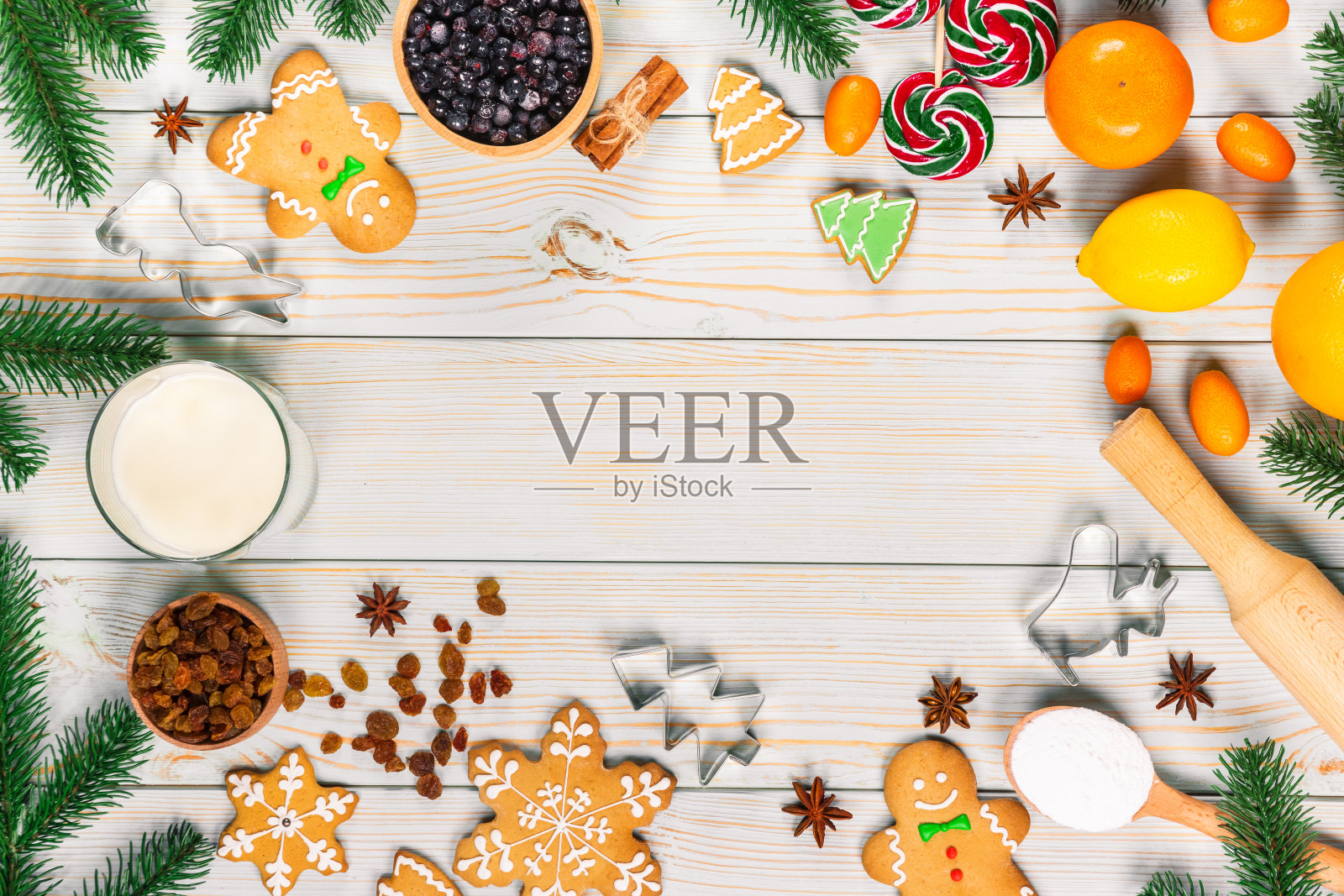 用面团、糖果和冬季香料在白色的木制桌子上制作圣诞姜饼。圣诞食品框背景照片摄影图片