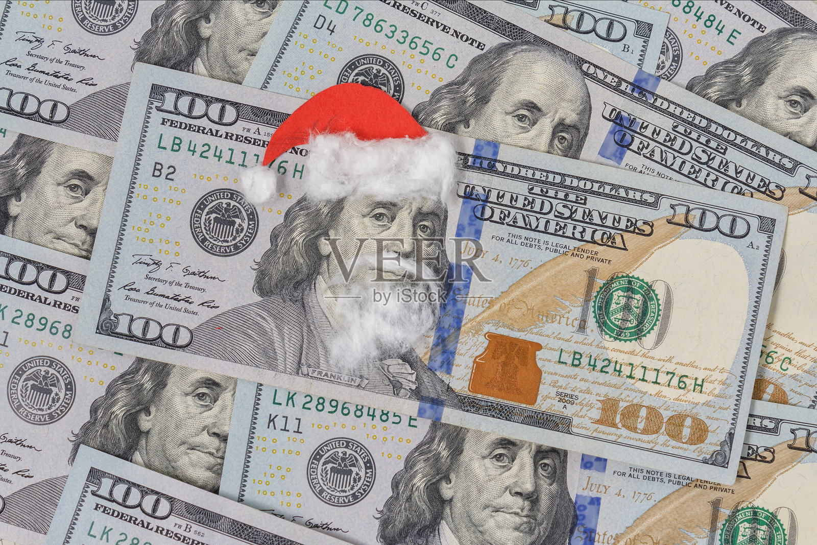 本杰明·富兰克林戴着圣诞老人帽印在钞票上。圣诞装饰品照片摄影图片