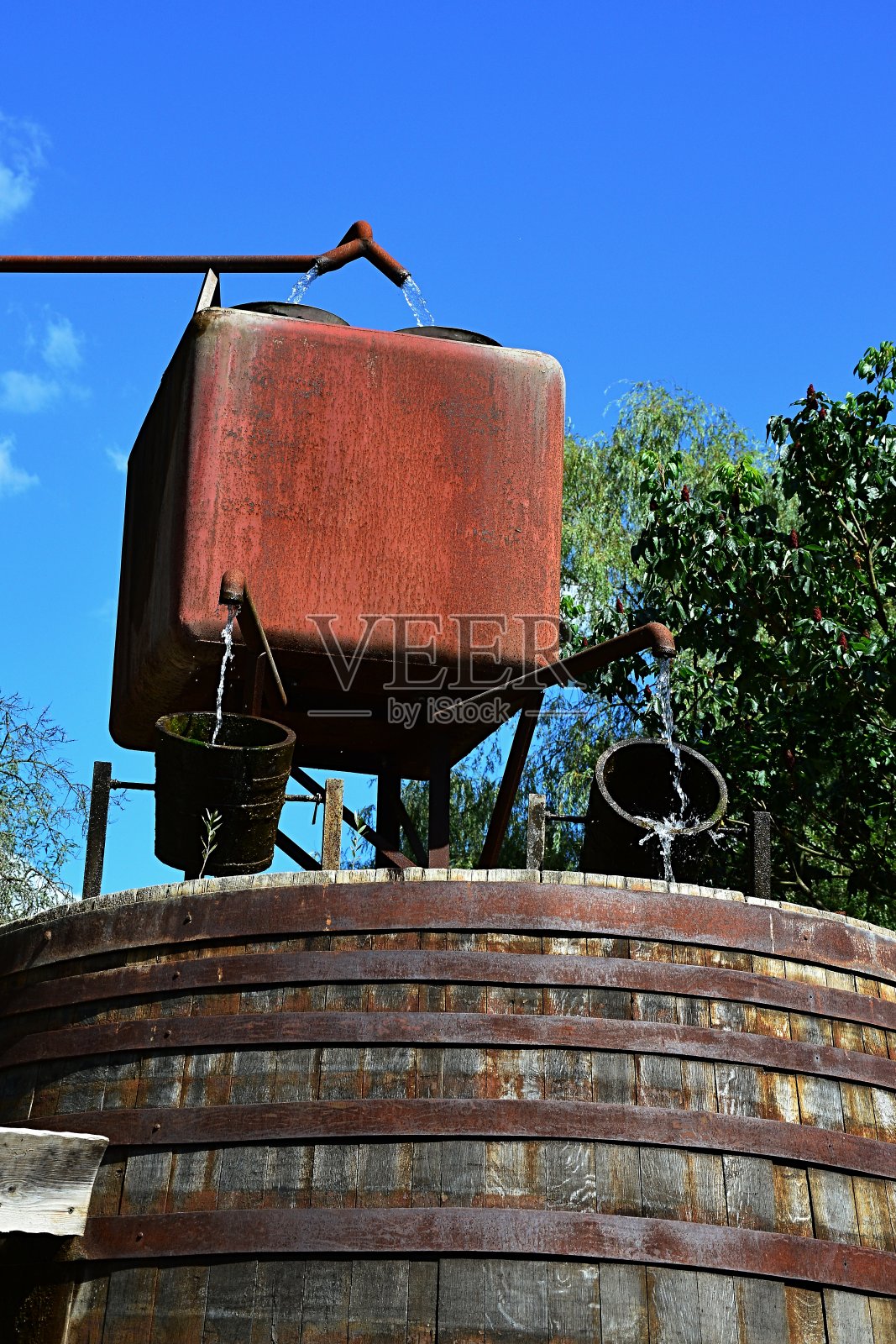 生锈的水管，方形的生锈流过水库和配水机构与两个木桶照片摄影图片