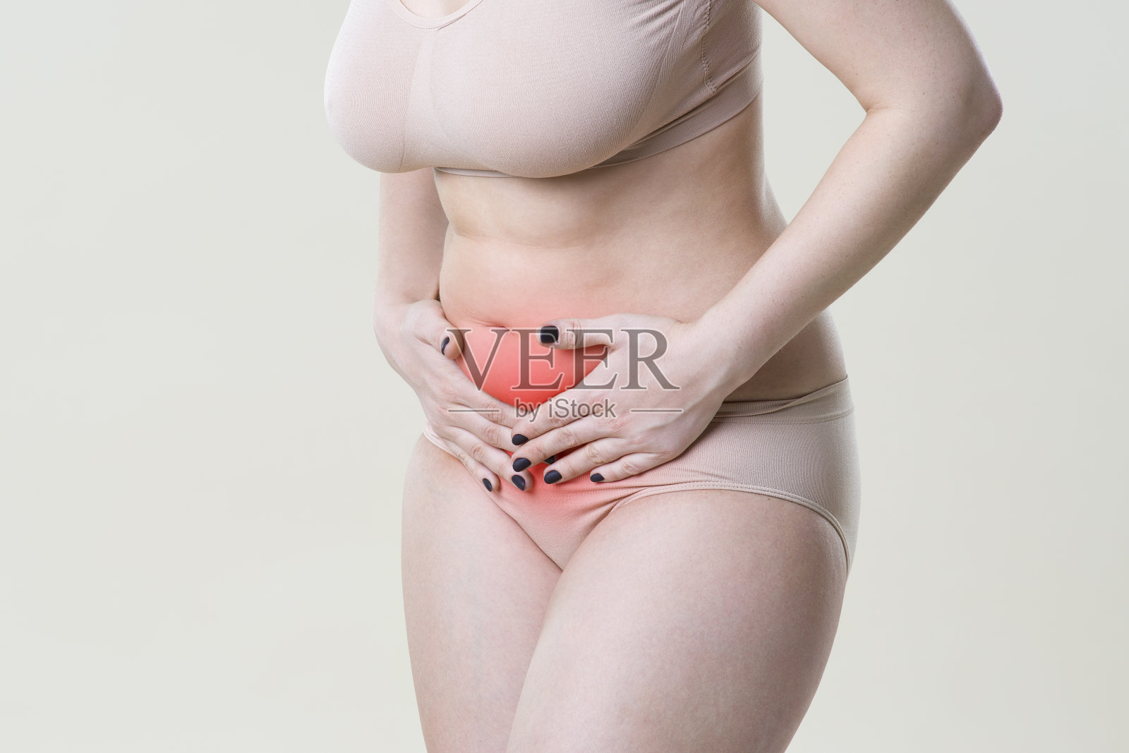 女人腹痛，米色背景上的腹痛照片摄影图片