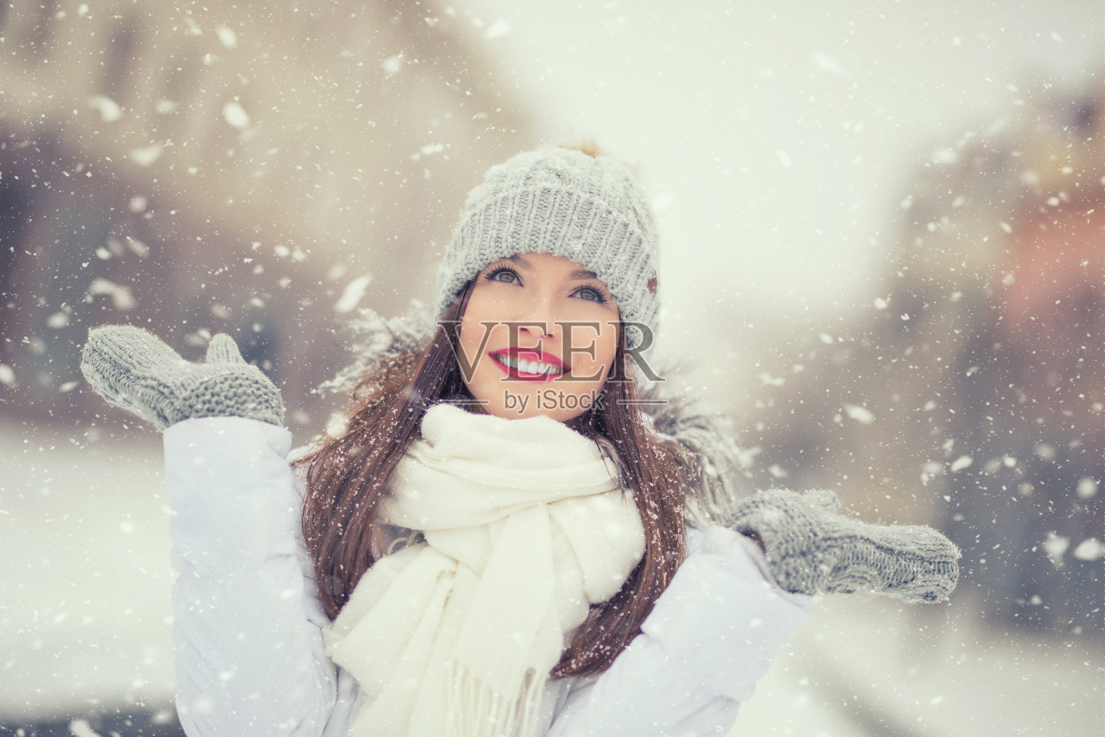 美丽的微笑年轻女子在温暖的衣服。肖像的概念在冬天下雪的天气照片摄影图片