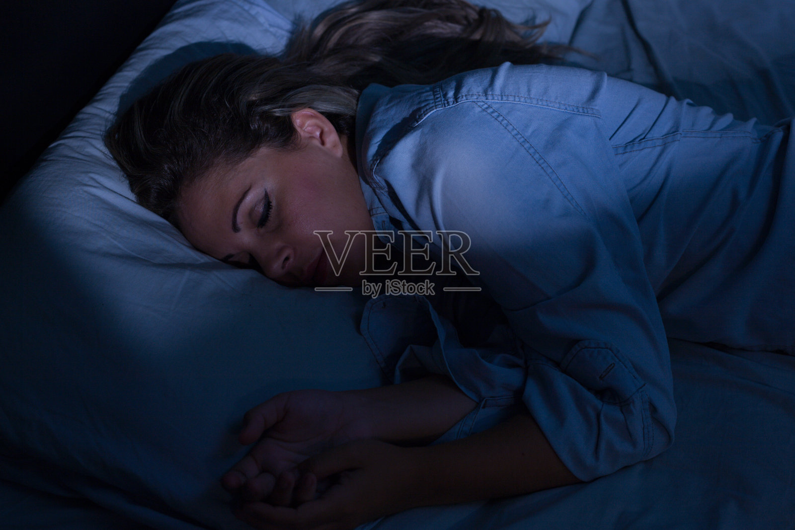晚上平静地睡在床上的女人照片摄影图片