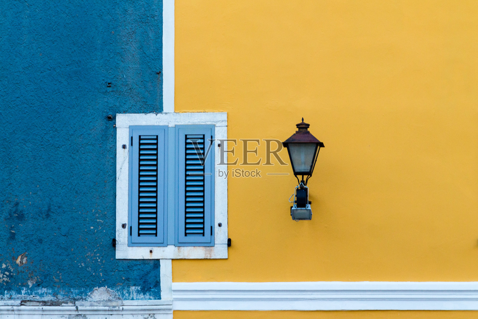 立面为蓝色和黄色，有窗户和路灯照片摄影图片
