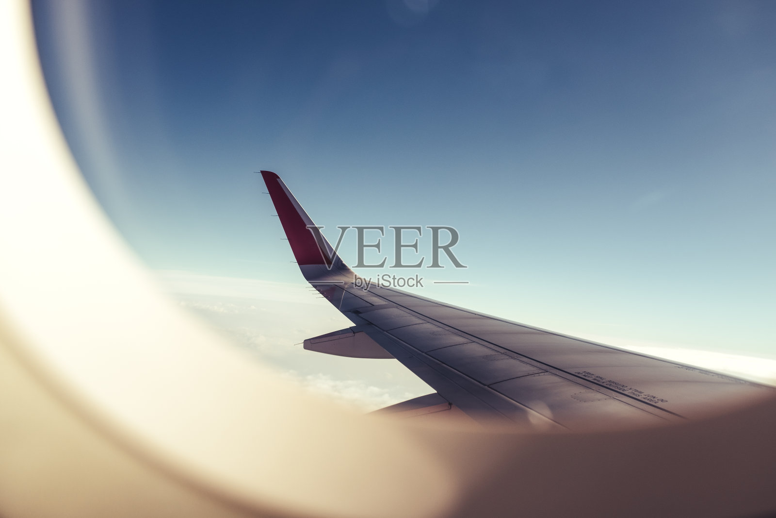 一个飞机机翼通过飞机窗户与蓝天背景照片摄影图片