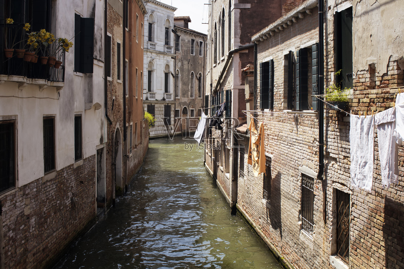 在威尼斯/意大利的一个古老的、历史的、典型的建筑上挂着洗过的衣服。图片展示了该地区的文化和生活方式。照片摄影图片