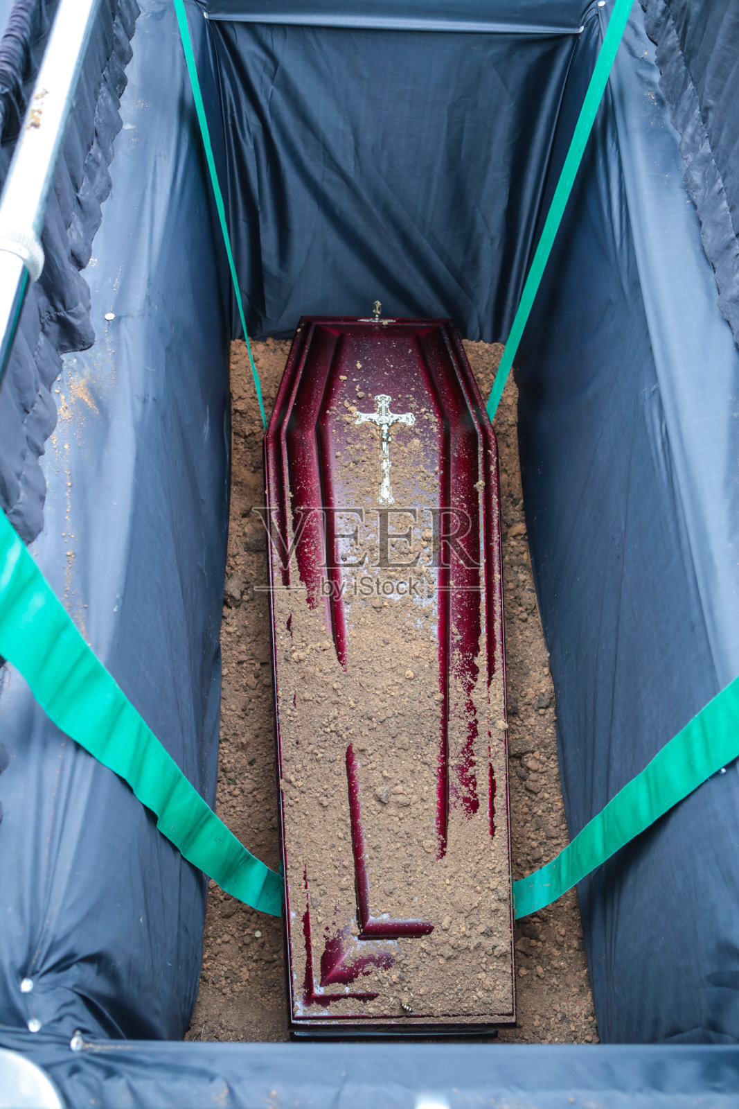 棺材在坟墓。埋在坟墓里的棺材上撒了土。传统的葬礼照片摄影图片