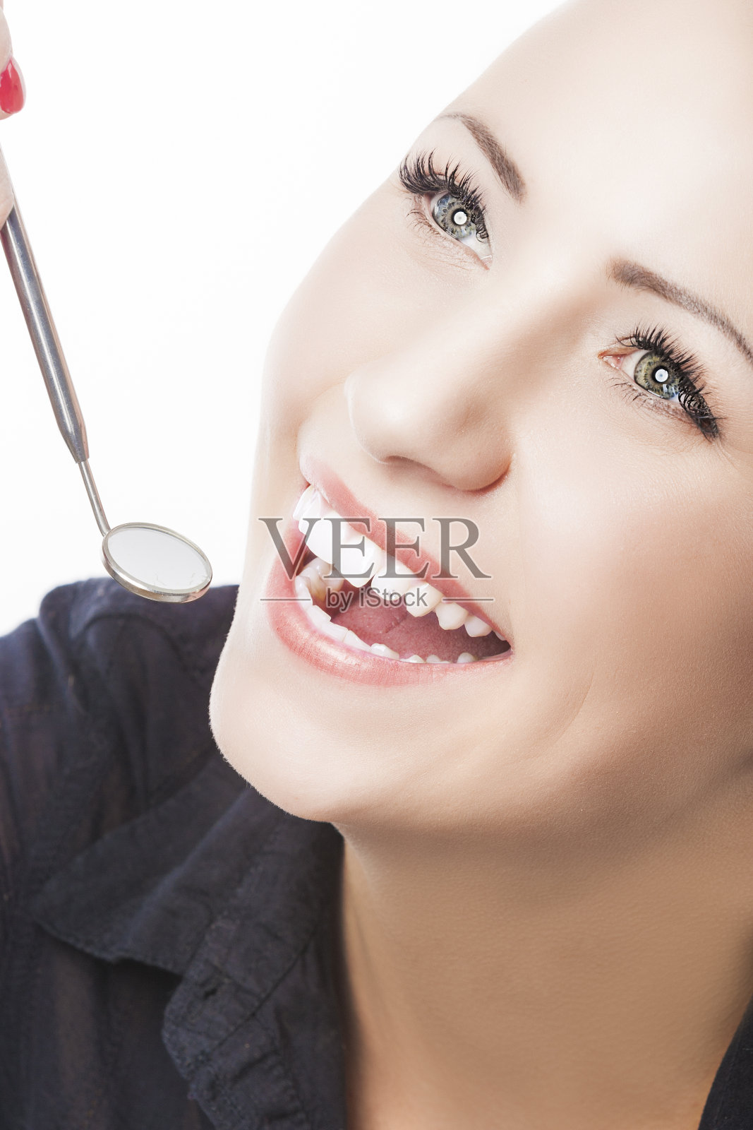 用口腔镜检查快乐女性患者的牙齿。照片摄影图片