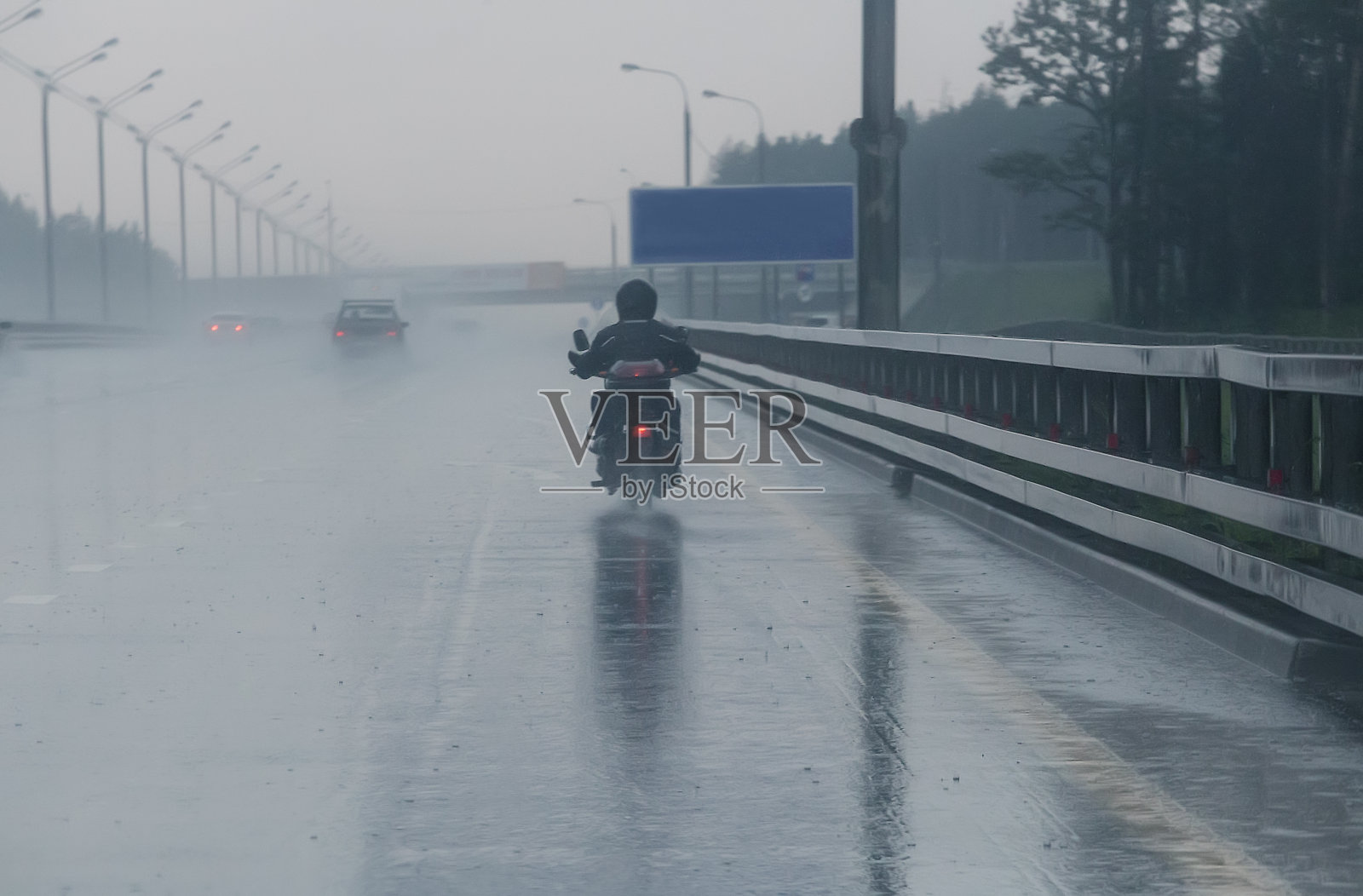 摩托车手骑着摩托车行进到雨天照片摄影图片