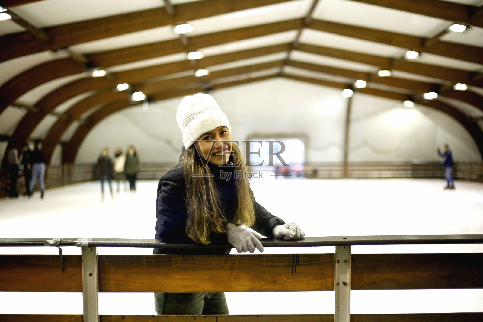 年轻漂亮的女孩在室内溜冰场滑冰照片摄影图片
