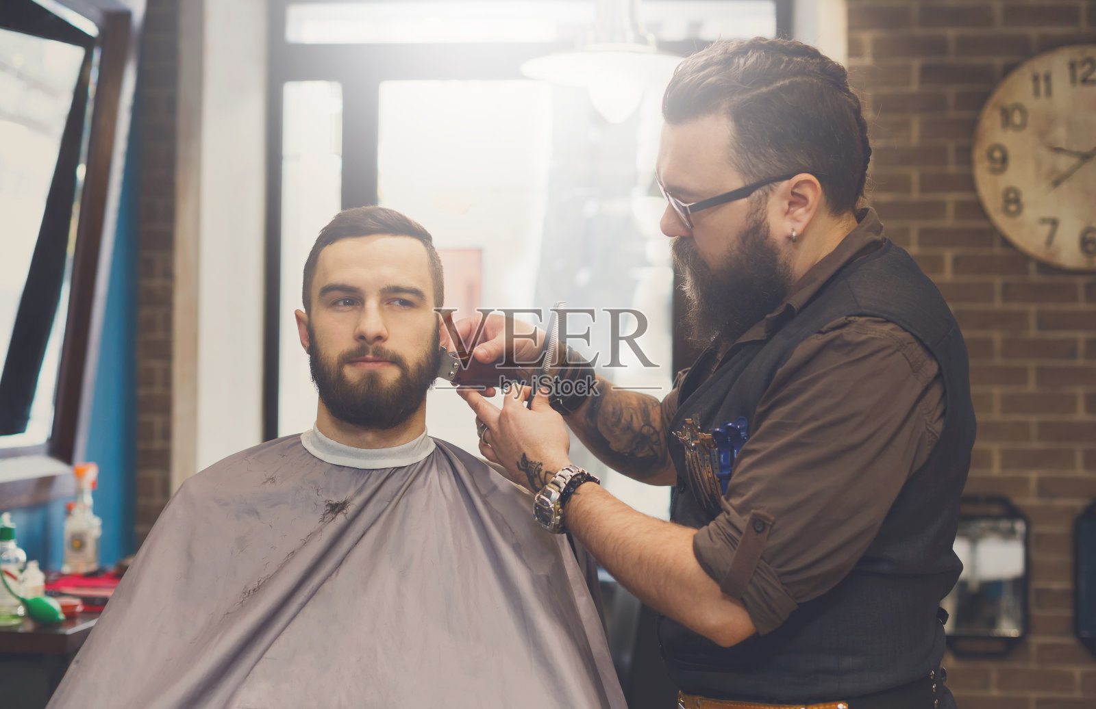 理发师在理发店里给一个男人理发照片摄影图片