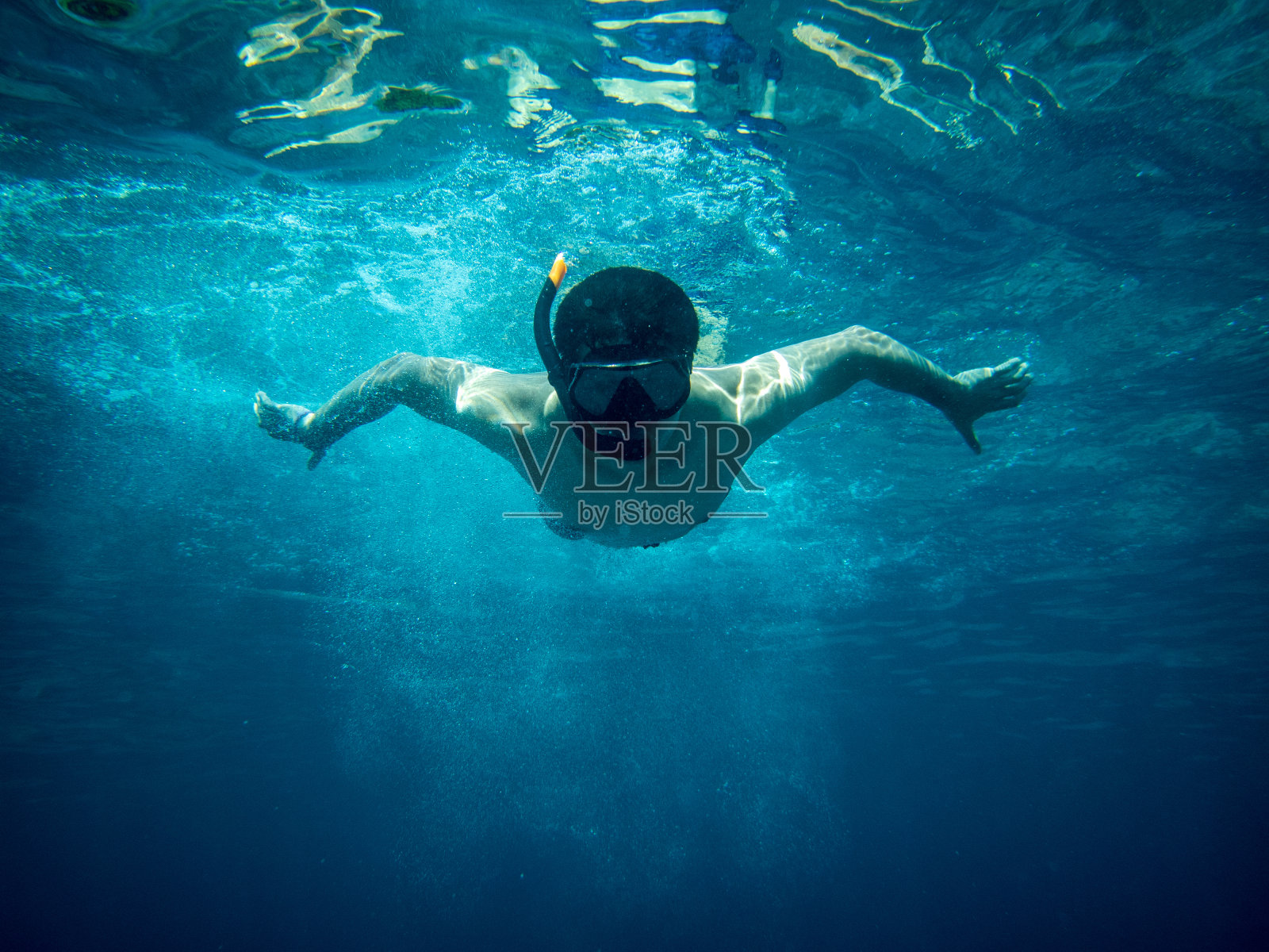 年轻的潜水员在蓝色的海洋下游泳照片摄影图片