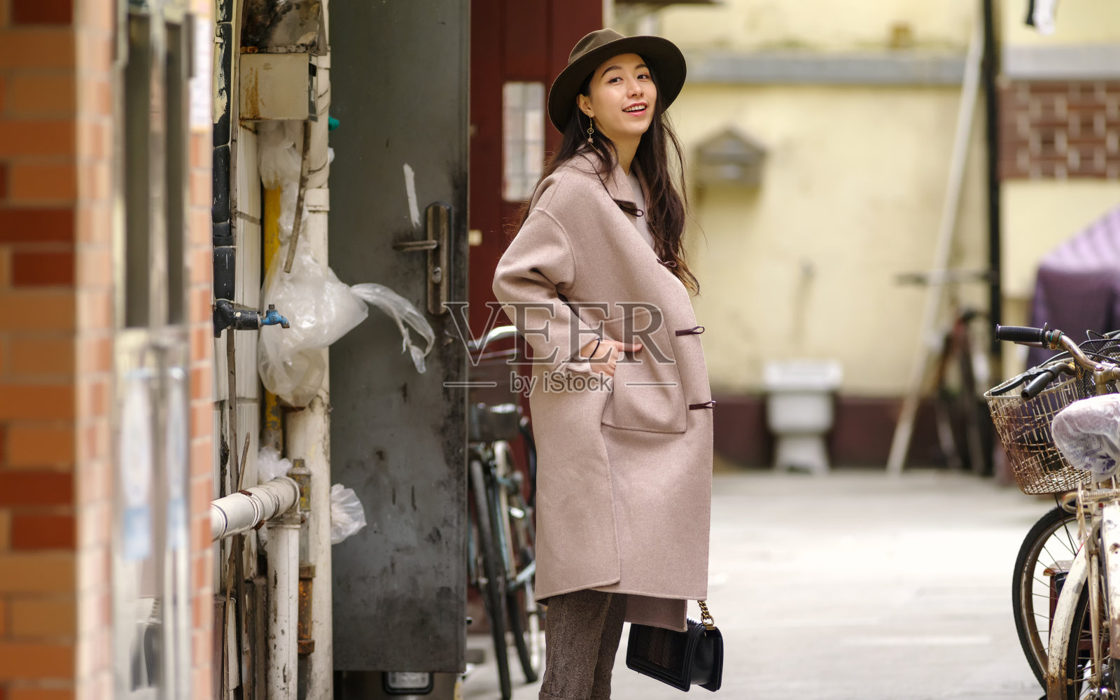 美丽的年轻女子身穿米色外套在秋天的城市。户外时尚写真魅力年轻的中国开朗时尚女士在街头。情感、人、美、生活理念。照片摄影图片