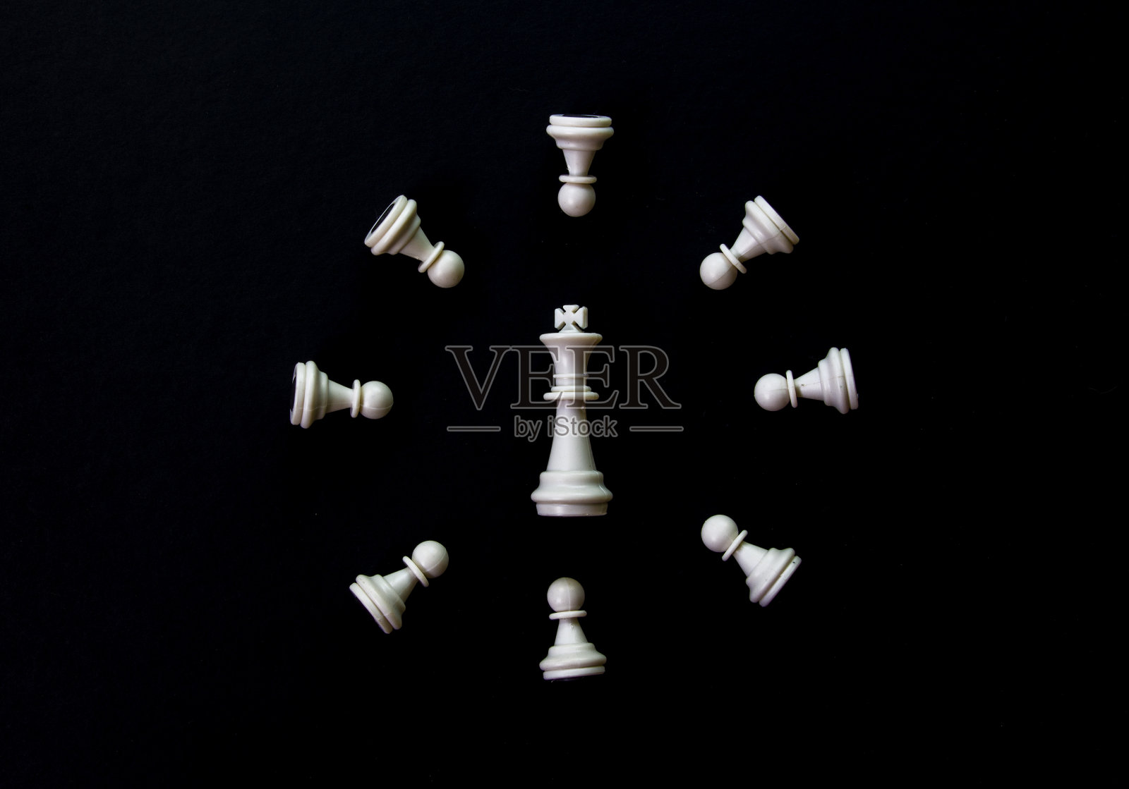白色棋钟在黑色背景上平躺照片。白色象棋人物抽象点缀。照片摄影图片