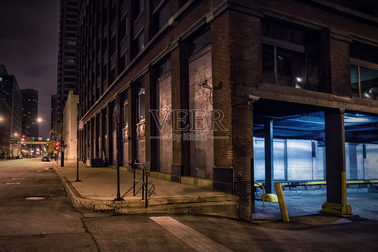 黑暗的城市市中心街角与工业仓库装载码头在晚上。照片摄影图片