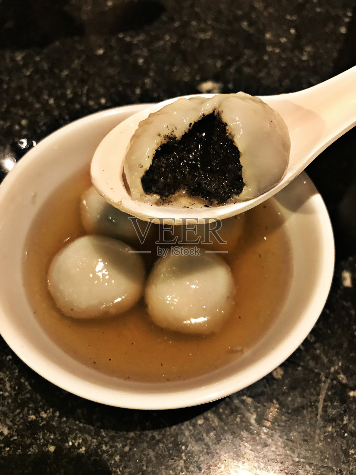 姜茶黑芝麻饺子。照片摄影图片