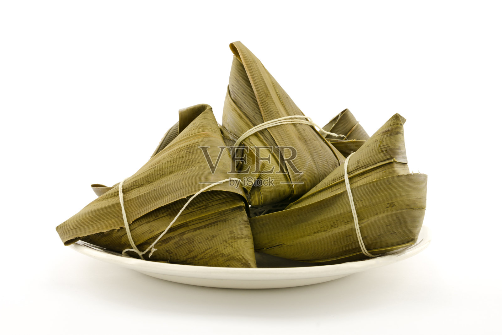 传统的粽子或粽子包在盘子上，孤立在白色的背景上照片摄影图片