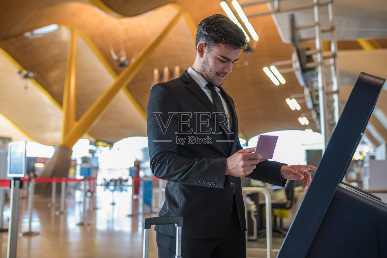 一个年轻的商人在机场的机器上做自我检查照片摄影图片
