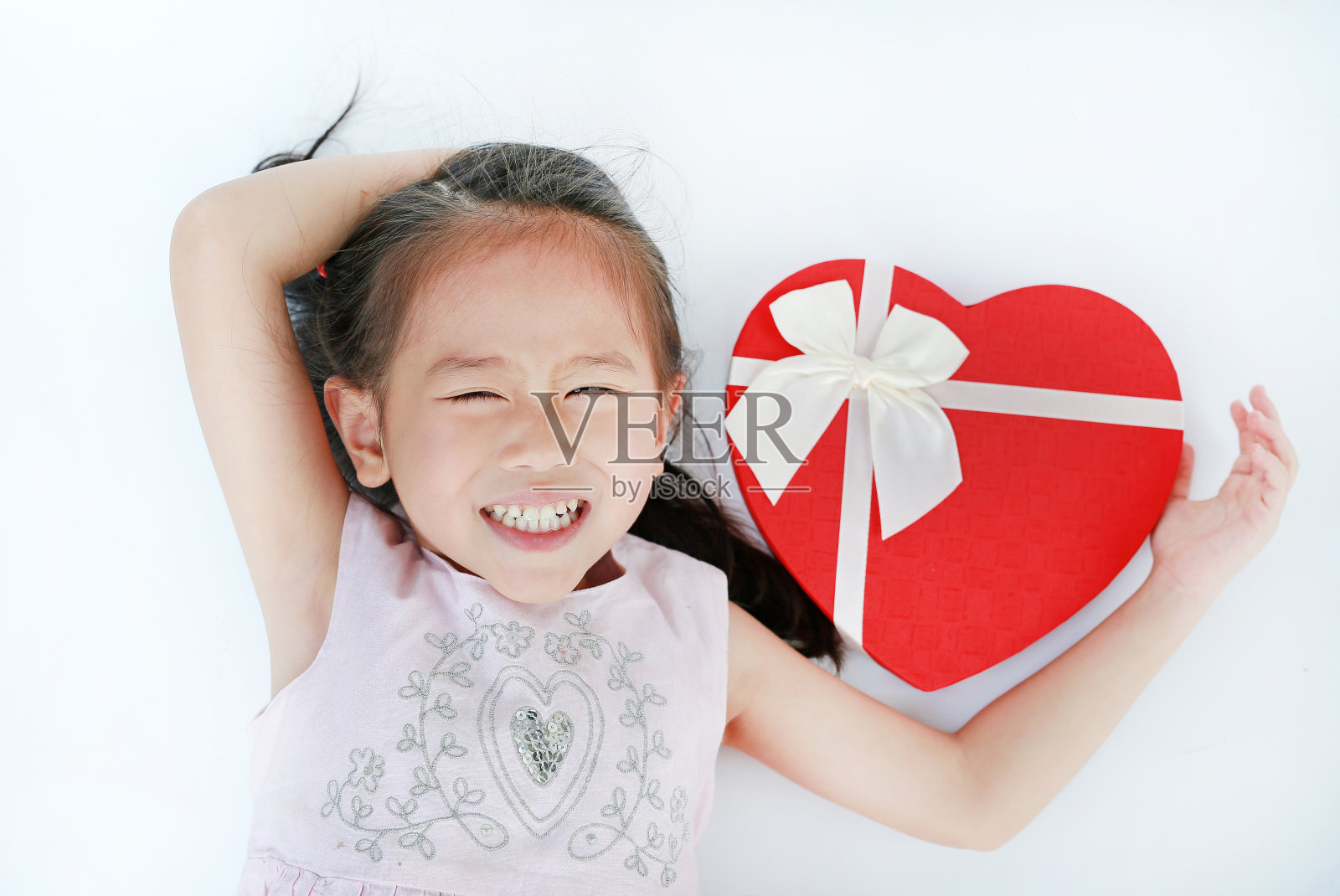 快乐的小亚洲女孩与红心礼盒孤立在白色的背景。情人节的概念。照片摄影图片