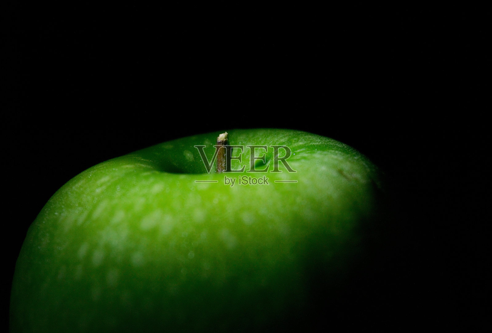 青苹果部分照明孤立在黑色背景照片摄影图片