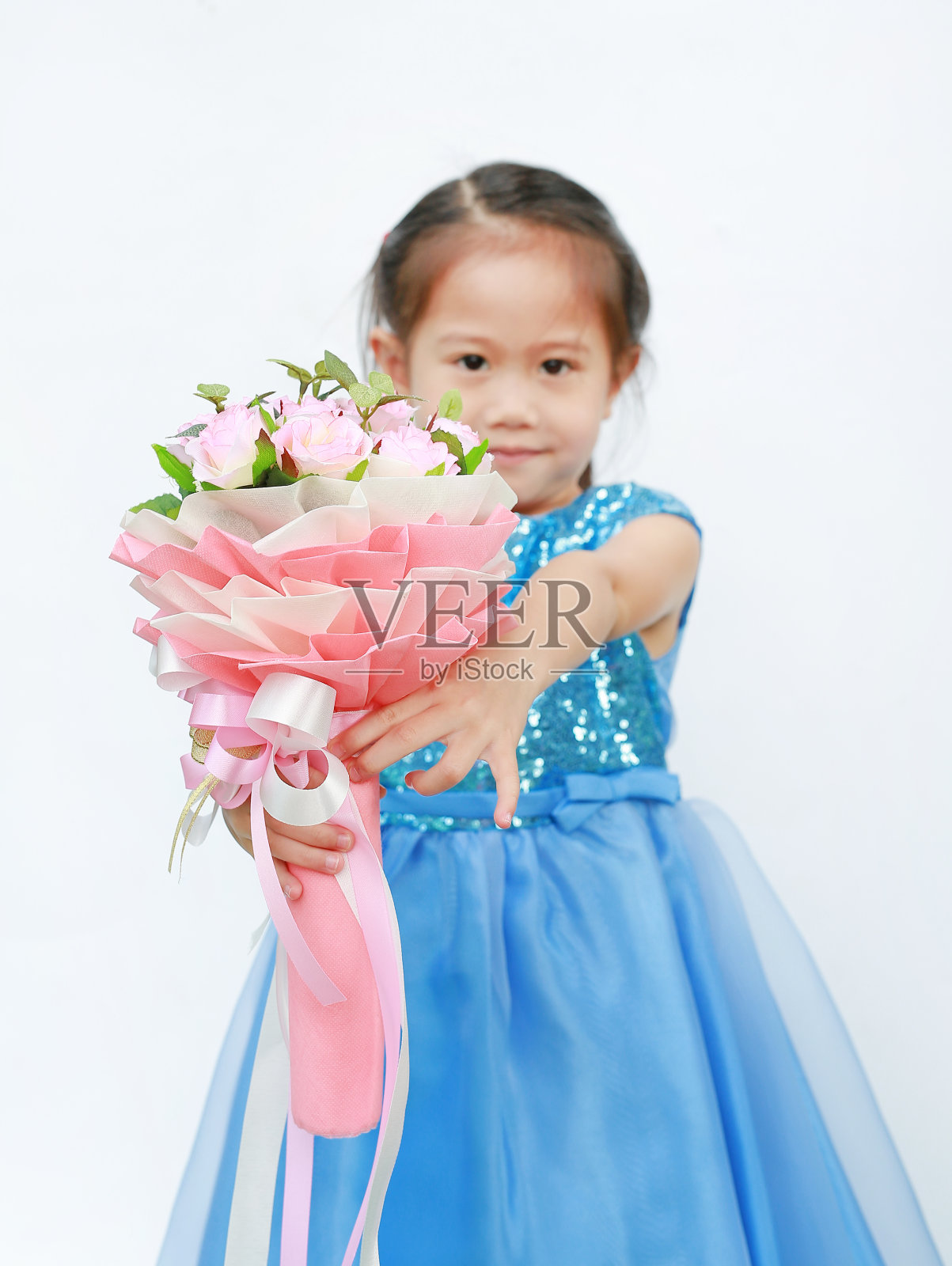 一个亚洲小女孩拿着一束玫瑰花参加情人节。专注于玫瑰花。照片摄影图片