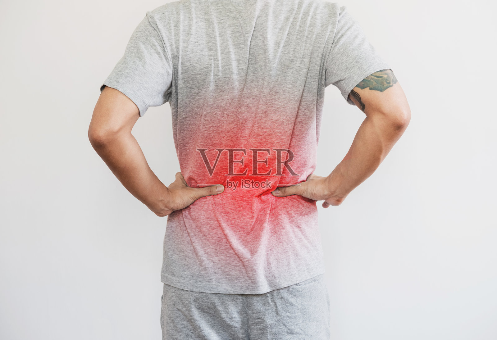 一个男人摸着背，用红色突出背疼的概念，背疼腰疼，放在白色的背景上照片摄影图片