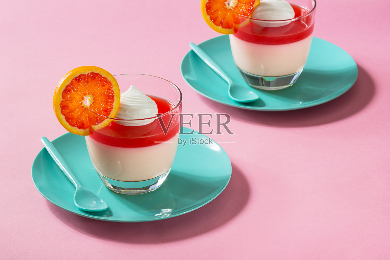 柑橘味意式奶冻淋上血橙冻和鲜奶油照片摄影图片